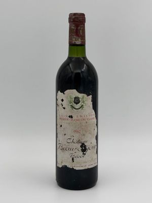 an old bottle of wine sitting on top of a white table