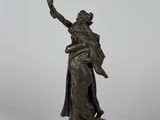 a bronze statue of a woman holding a sword on a rock