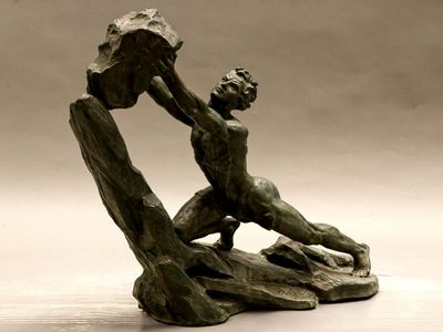 une statue en bronze d'un homme assis sur un rocher