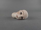 a small doll head that is on a table