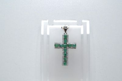 une petite croix verte exposée dans une vitrine transparente