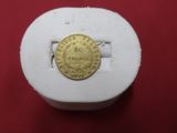 a gold coin sitting on top of a white box