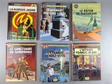six books of french comics are lined up on a table