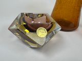 un vase en verre marron et un autre vase en verre marron posés sur une table blanche