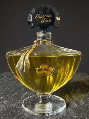 a bottle of perfume sitting on top of a rock
