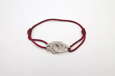 un bracelet en fil rouge orné d'un pendentif représentant l'œil maléfique