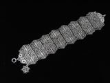 an old silver bracelet with intricate designs on a black background