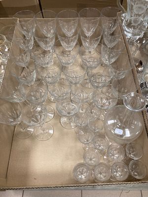 des bouteilles et des verres sont disposés sur un plateau posé par terre