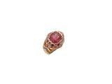gros plan d'une bague en or avec une pierre rose
