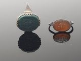 deux bagues sur lesquelles figurent une pièce de monnaie et un visage