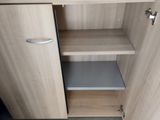 a wooden cabinet with a door and a shelf in the corner