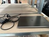 un ordinateur portable posé sur une table à côté d'un chargeur