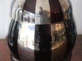 a black and silver vase sitting on a wooden table