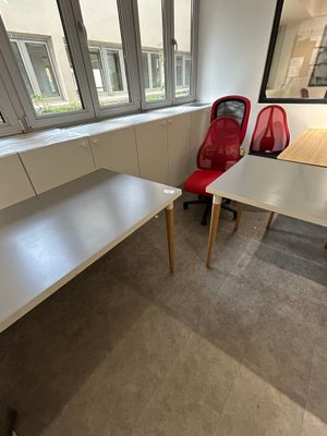 two red chairs and a white desk in an office