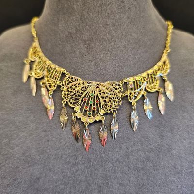 une femme portant un collier en or orné de plumes