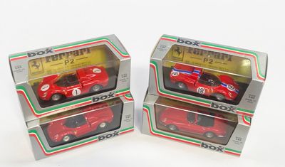 trois boîtes contenant des petites voitures rouges, posées sur une surface blanche