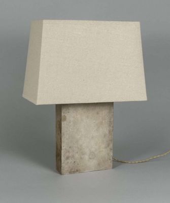 concrete table lamp with a linen shade on a grey background