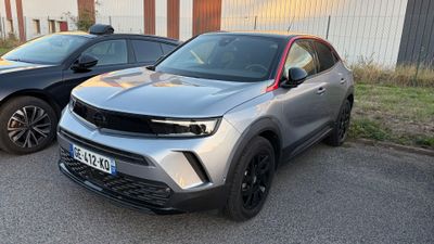 deux voitures garées côte à côte devant un immeuble