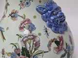 a blue and white vase with flowers and birds on it