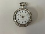 a silver pocket watch with roman numerals on the face