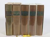 quatre livres sont alignés sur une surface blanche