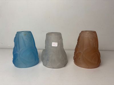 three different colored vases sitting on a white surface