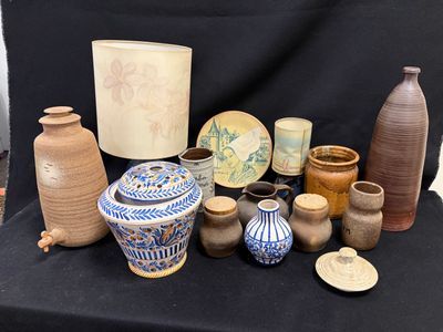 de nombreux vases de styles variés posés sur une table noire