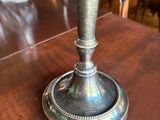 a silver candle that is sitting on a wooden table