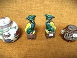 Trois figurines chinoises sont posées les unes à côté des autres sur une table