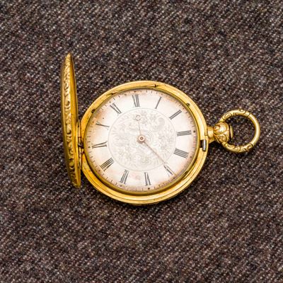 une montre de poche en or avec des chiffres romains