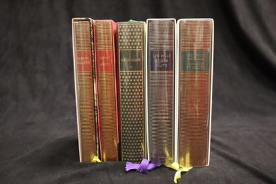 trois livres sont empilés les uns sur les autres sur un fond noir
