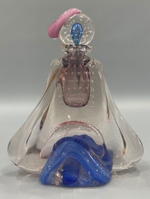 a glass figurine of a woman with a hat on top of her head