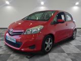 the red toyota yaris is parked on a checkered floor