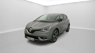 Une voiture grise est garée dans une pièce blanche au sol blanc.