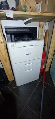 a white printer and a red fire hydrant in the corner of a room