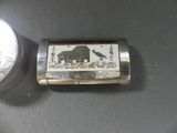 a silver lighter with a picture of a house on it