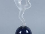 the figurine is sitting on top of a ball with smoke coming out of it