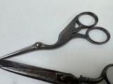 two pairs of scissors sitting on a white surface