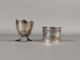 deux tasses en argent et une cuillère en argent posées sur une table