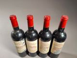 four bottles of wine are lined up on a table