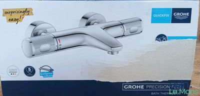 un carton contenant le nouveau robinet de salle de bains Grohe, encore dans son emballage d'origine