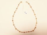 gold plated chain necklace with a flower design on a white background