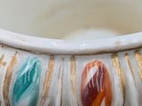 a close up of a white vase with colorful designs on it