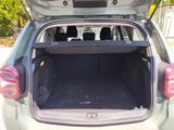the back of a car with its trunk open and the back of the car filled with luggage