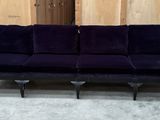 une image représentant un canapé violet posé sur un sol recouvert de moquette