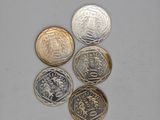 four different types of coins sitting on top of a white surface