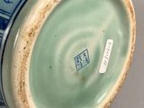 a blue and white vase sitting on a table