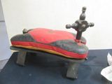 a red and black pillow on top of a wooden bench