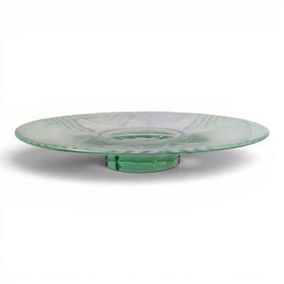 a close up of a green glass plate on a white background