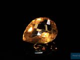 gros plan d'un diamant jaune sur une surface noire